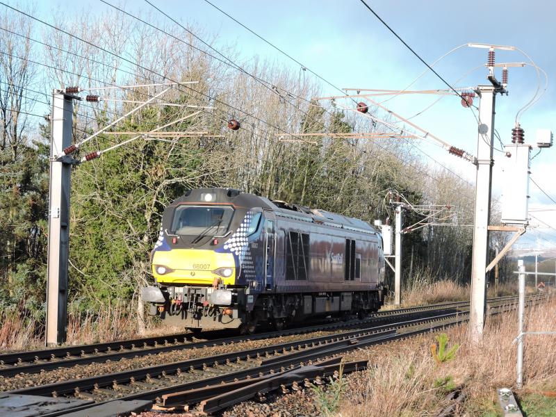 68007: 68007 at Byrehill Junction (just south of Kilwinning) on 0Z41 move from Kingmoor to Motherwell. Looks like it is running wrong line but it isn't, the white marker lights are showing on both ends of the loco. Photo of 68007