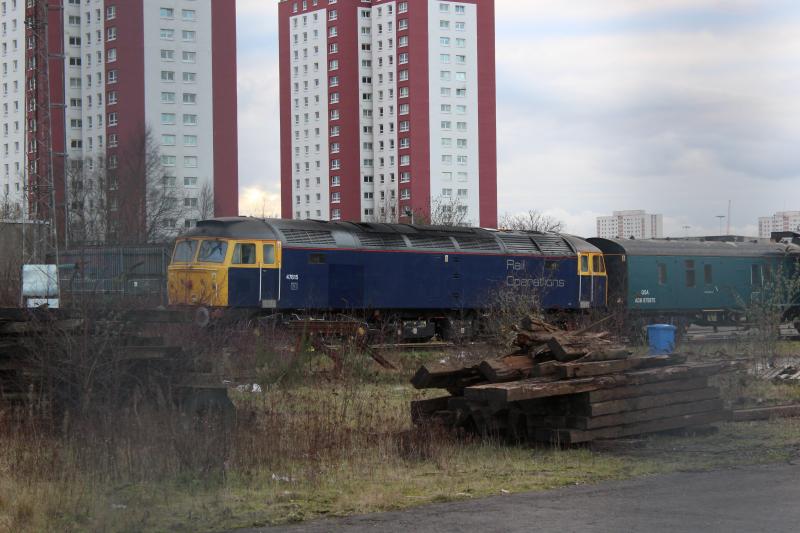 47815 in the sidings at Glasgow Works: Rail Operations Group 47815 parked up in Knorr-Bremse Glasgow Works after working today's 5T06 from Shields with 320302 and QSA Barriers. Photo of 47815 in the sidings at Glasgow Works