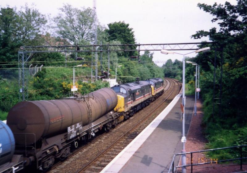 Through Drumchapel: 37424 ISLE OF MULL and 37410 ALUMINIUM 100 at Drumchapel in June 1993 with the morning train from Corpach to Coatbridge and Mossend. This was the locos return working off the overnight alumina train from Blyth. Photo of Through Drumchapel