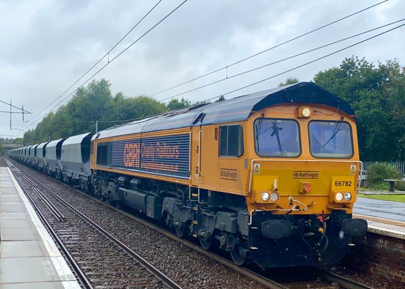 Charitable Aggregates: In a torrential downpour, GB Railfreight 66782 carrying Charity Railtour decals, applies power as it passes through Holytown working 6E32 Mossend - Hunslet Aggregate hoppers. (21/08/2021) Photo of Charitable Aggregates