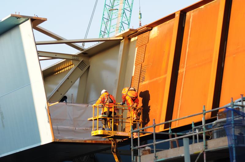 Scale Of The Sections: Two workers carry out some preperation work on Saturday afternoon before the start of the push of 2400 tonnes of steel across the WCML at Eglington Street Photo of Scale Of The Sections